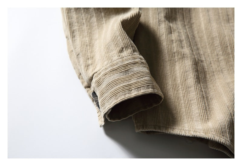 Close-up of a tan shirt sleeve cuff beside the textured body and hem.