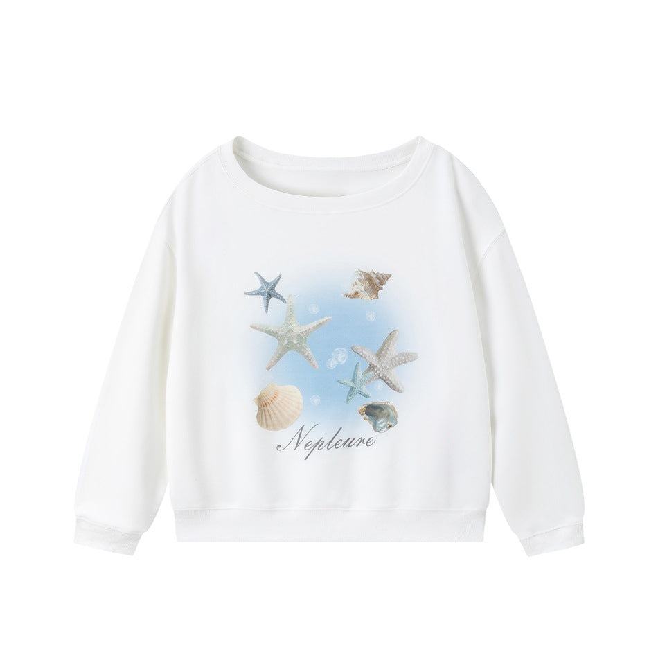 White crewneck sweatshirt with a blue gradient starfish and seashell print and script lettering on the front