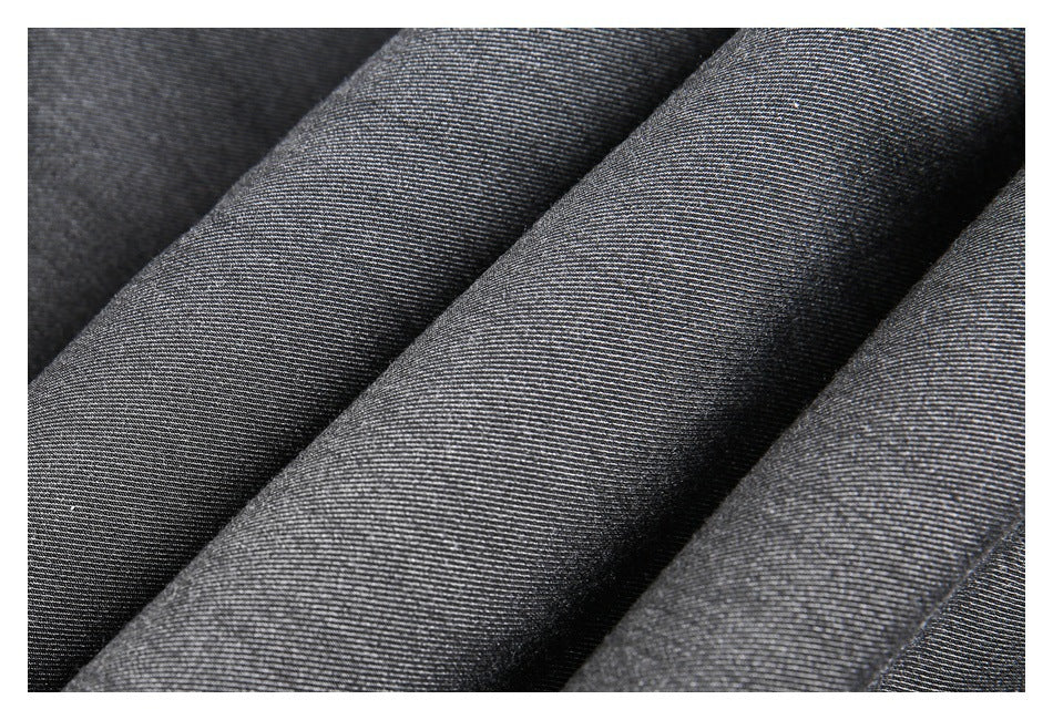 Close-up of dark gray woven fabric arranged in folds, showing its fine diagonal texture.