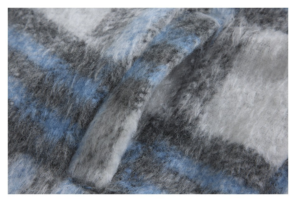 Close-up of fuzzy blue, charcoal gray, and white plaid fabric.