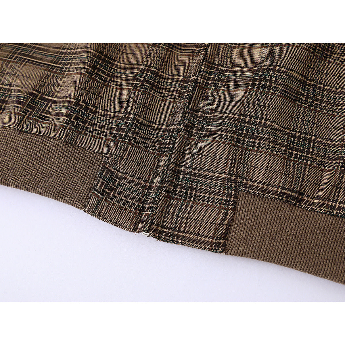 Close-up of the brown plaid jacket's ribbed brown hem and lower zipper.