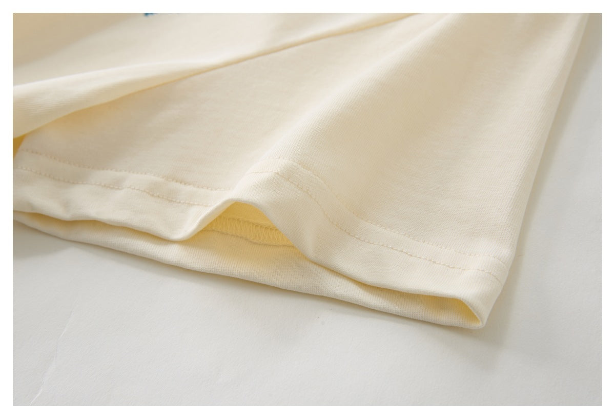Close-up of the cream garment's folded hem and stitched edge.