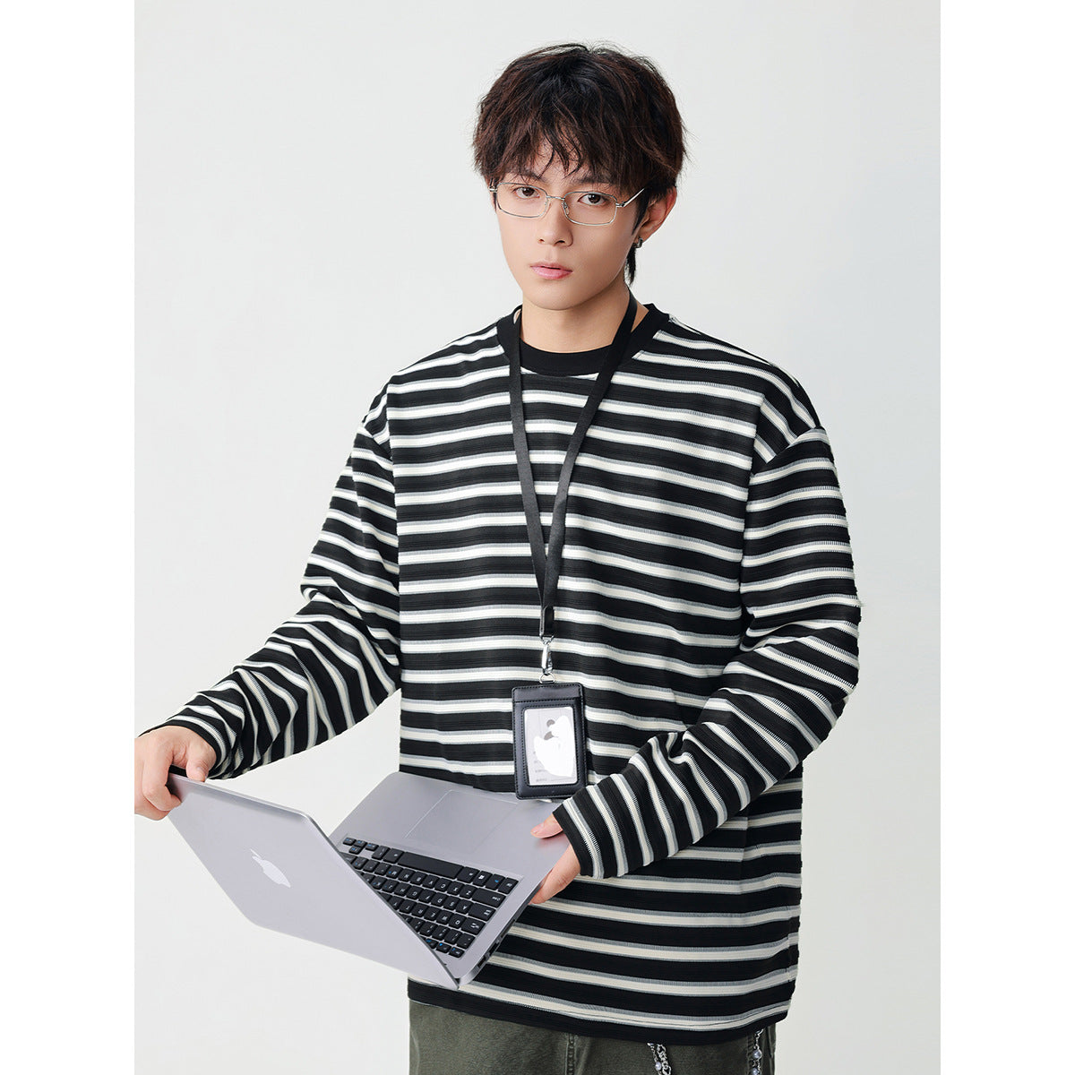 Model wearing an oversized black long-sleeve shirt with white and gray horizontal stripes and a black crew neck.
