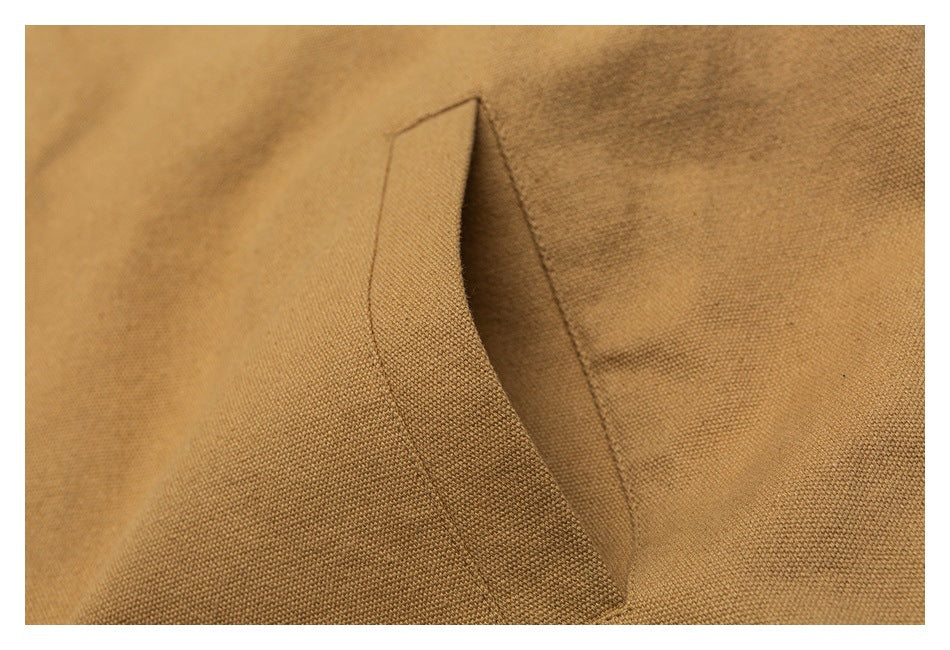 Close-up of a welt pocket opening on tan jacket fabric.