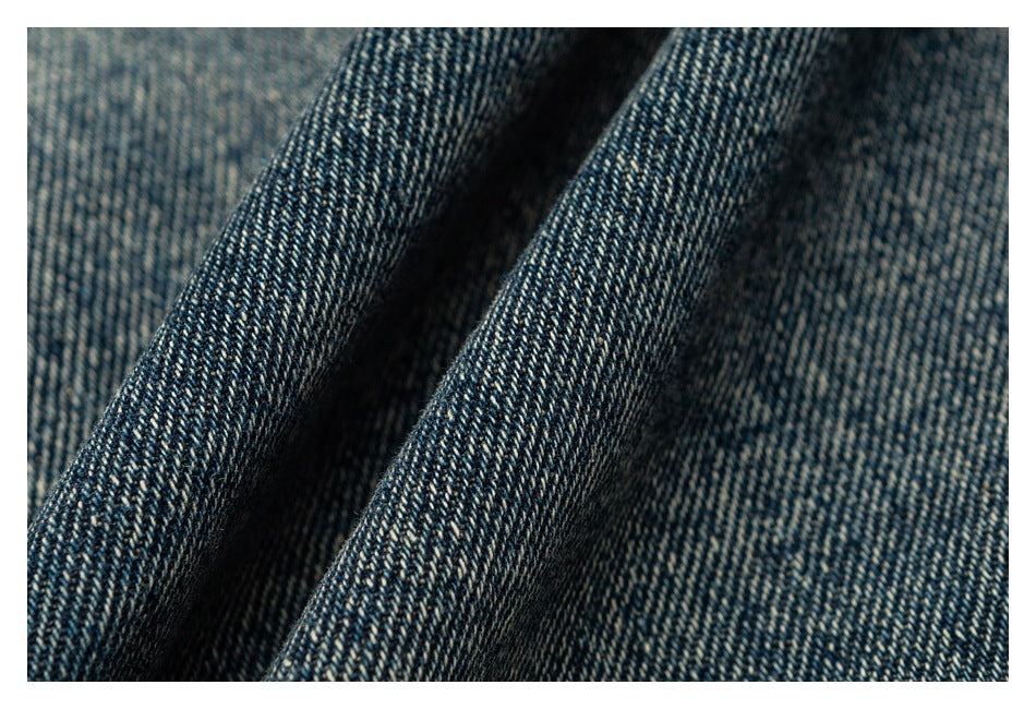 Macro view of the textured weave of dark blue denim fabric.