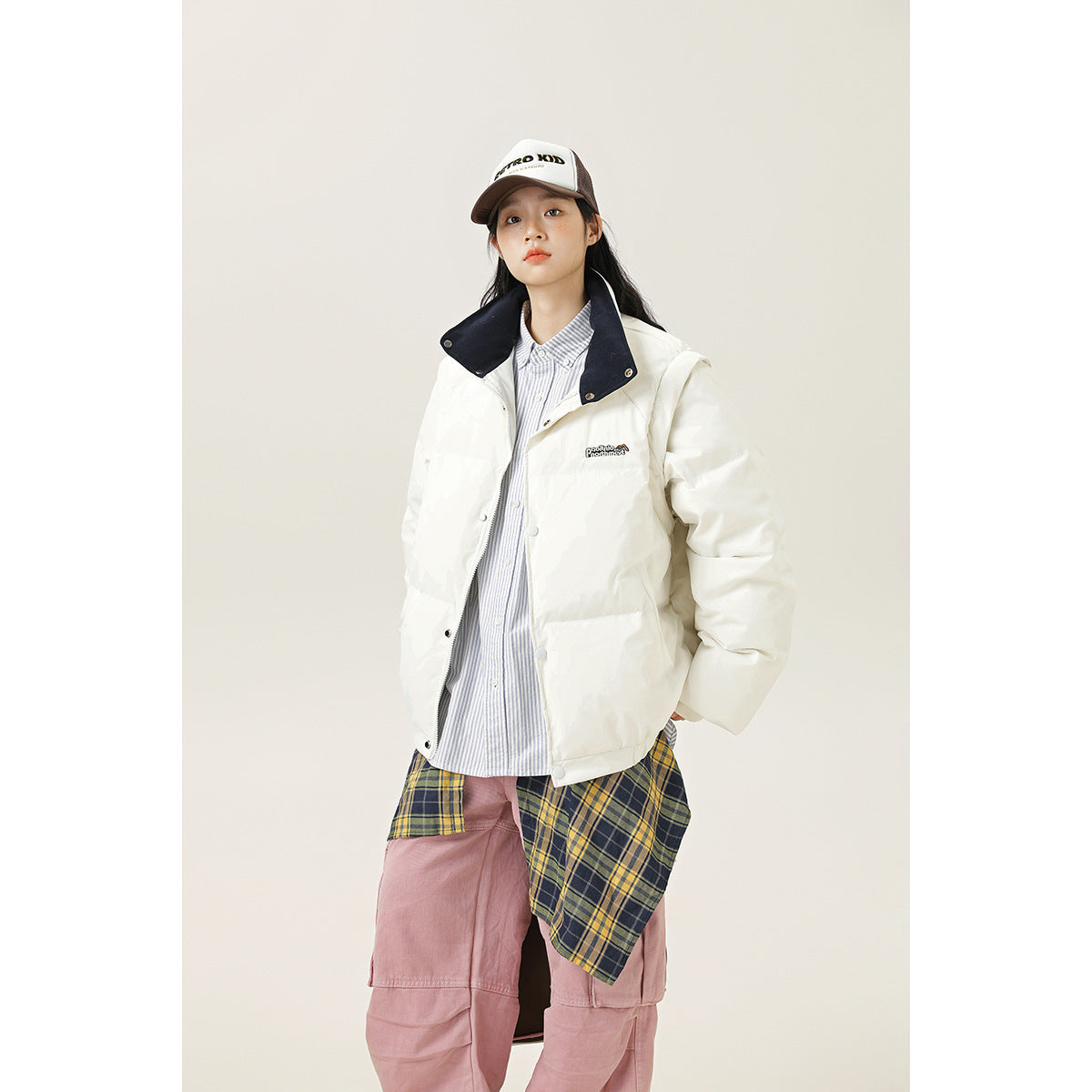 Model wearing a white padded jacket with a dark navy stand collar and snap-front closure.