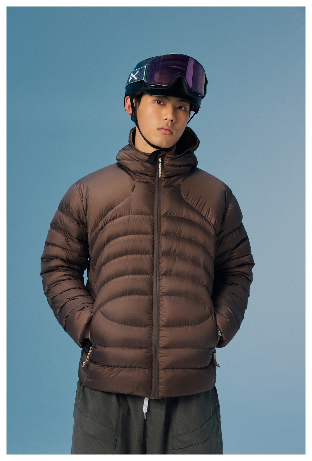 Front view of a model wearing a dark brown hooded puffer jacket with a full-length zipper.