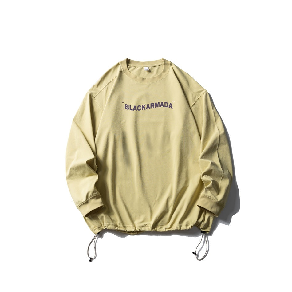 Pale yellow long-sleeve crew-neck top with purple chest text print and drawstring hem, flat lay
