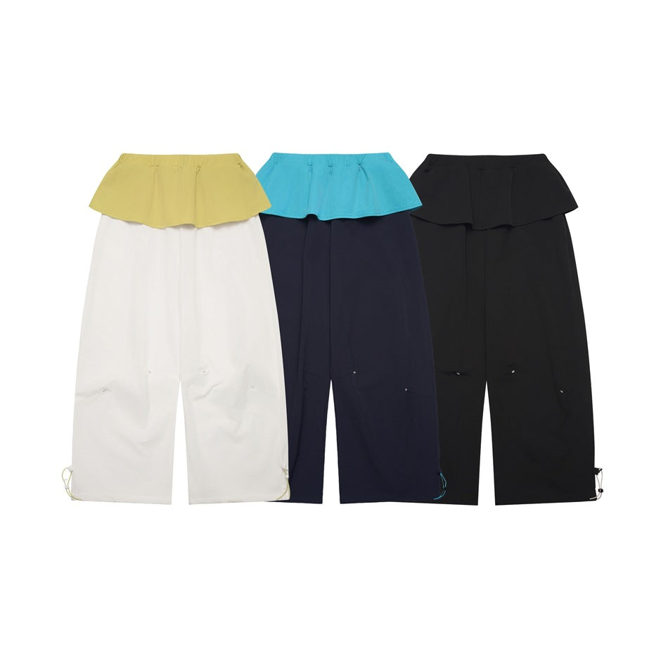 Three colorways of wide-leg pants with flounced overlays: white and yellow, navy and turquoise, and all black.
