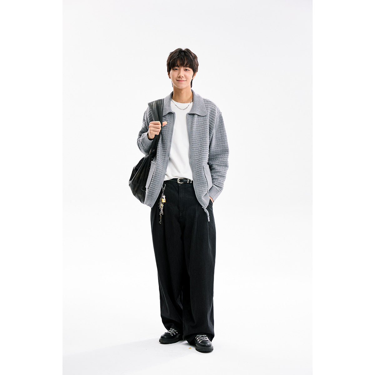 Model wearing a light gray textured collared cardigan over a white shirt with wide black trousers.