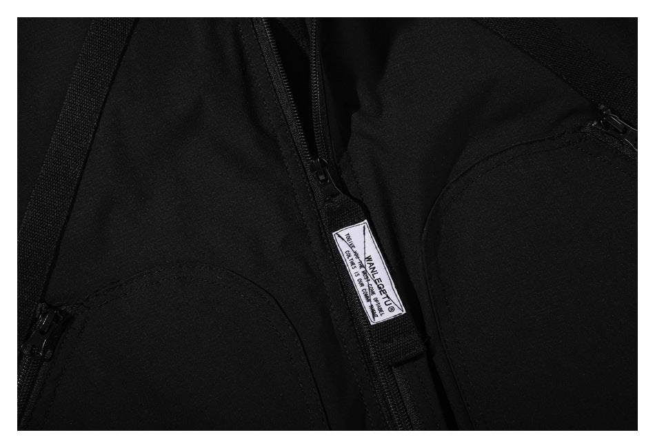 Close-up of a black jacket showing its zipper, pockets, and sewn-in label.