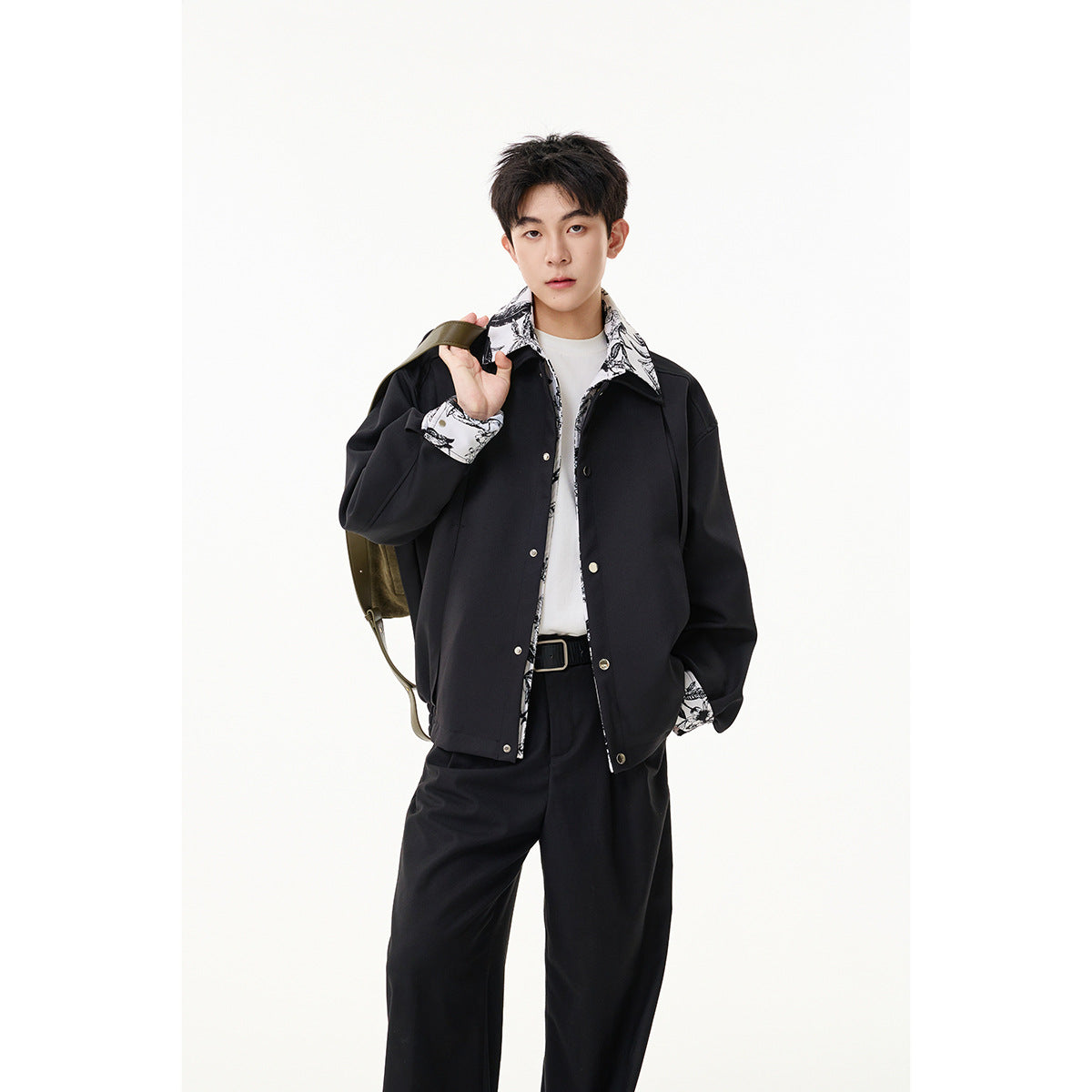 Model wearing a black jacket with black-and-white botanical print details at the collar, cuffs, and placket.