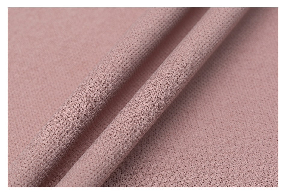 Close-up of dusty rose perforated fabric draped into soft folds.
