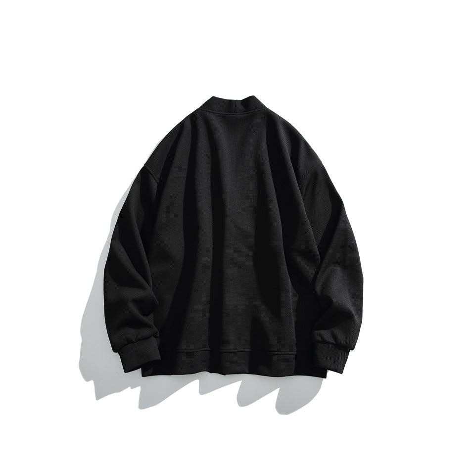 Back view of a black loose-fit jacket with a short stand collar, long sleeves, ribbed cuffs and hem.