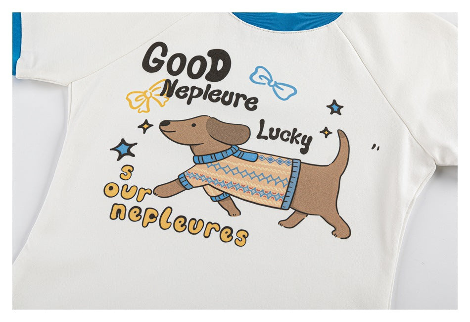 Front view of a white short-sleeve shirt with blue trim and a colorful cartoon dog wearing a patterned sweater.
