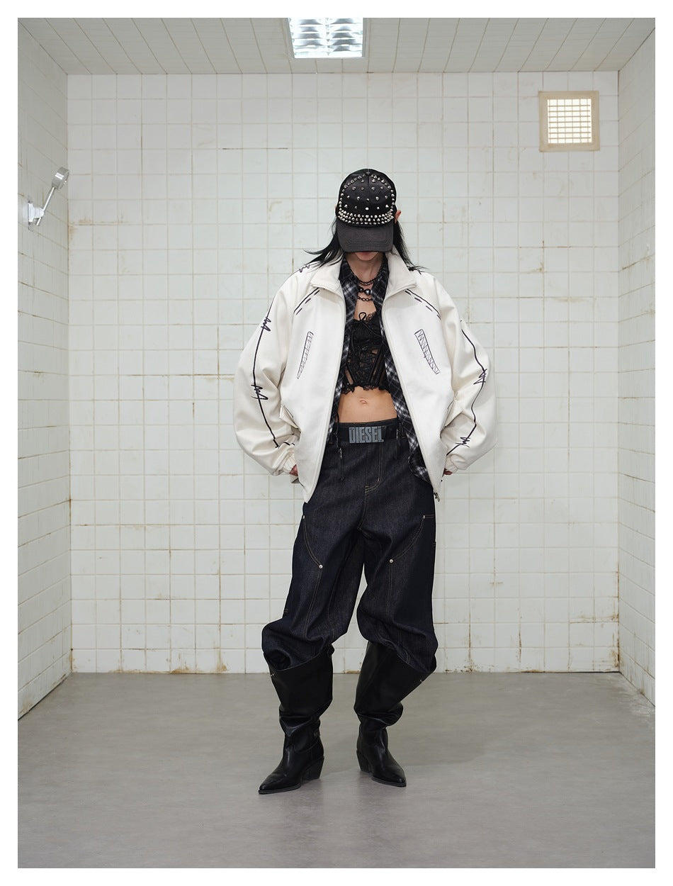 Model with hands in pockets wearing an off-white printed jacket, studded cap, dark jeans and black boots