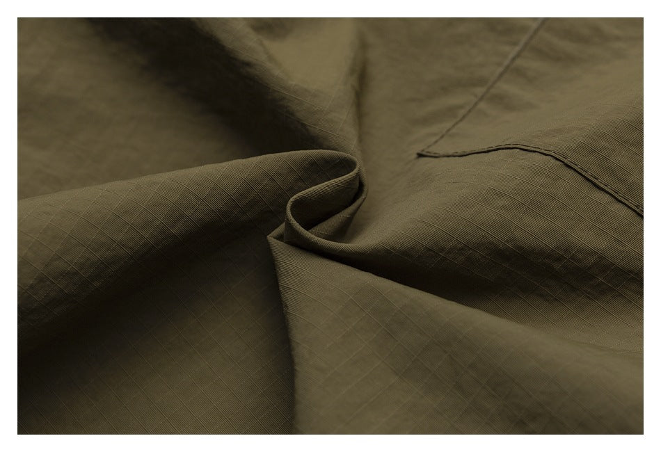 Close-up of olive-khaki pants fabric, stitching, and a curved seam.