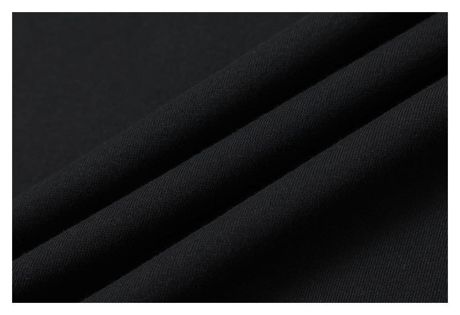 Close-up of black fabric arranged in diagonal folds, showing its fine knit texture.