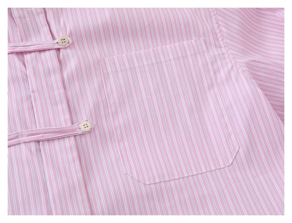Close-up of the chest pocket and decorative button tabs on a pink and white striped shirt.