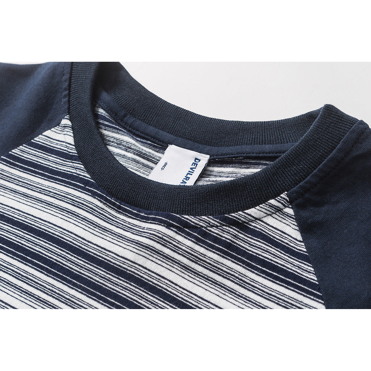 Close-up of a navy-and-white striped T-shirt neckline with a ribbed collar and visible brand label.