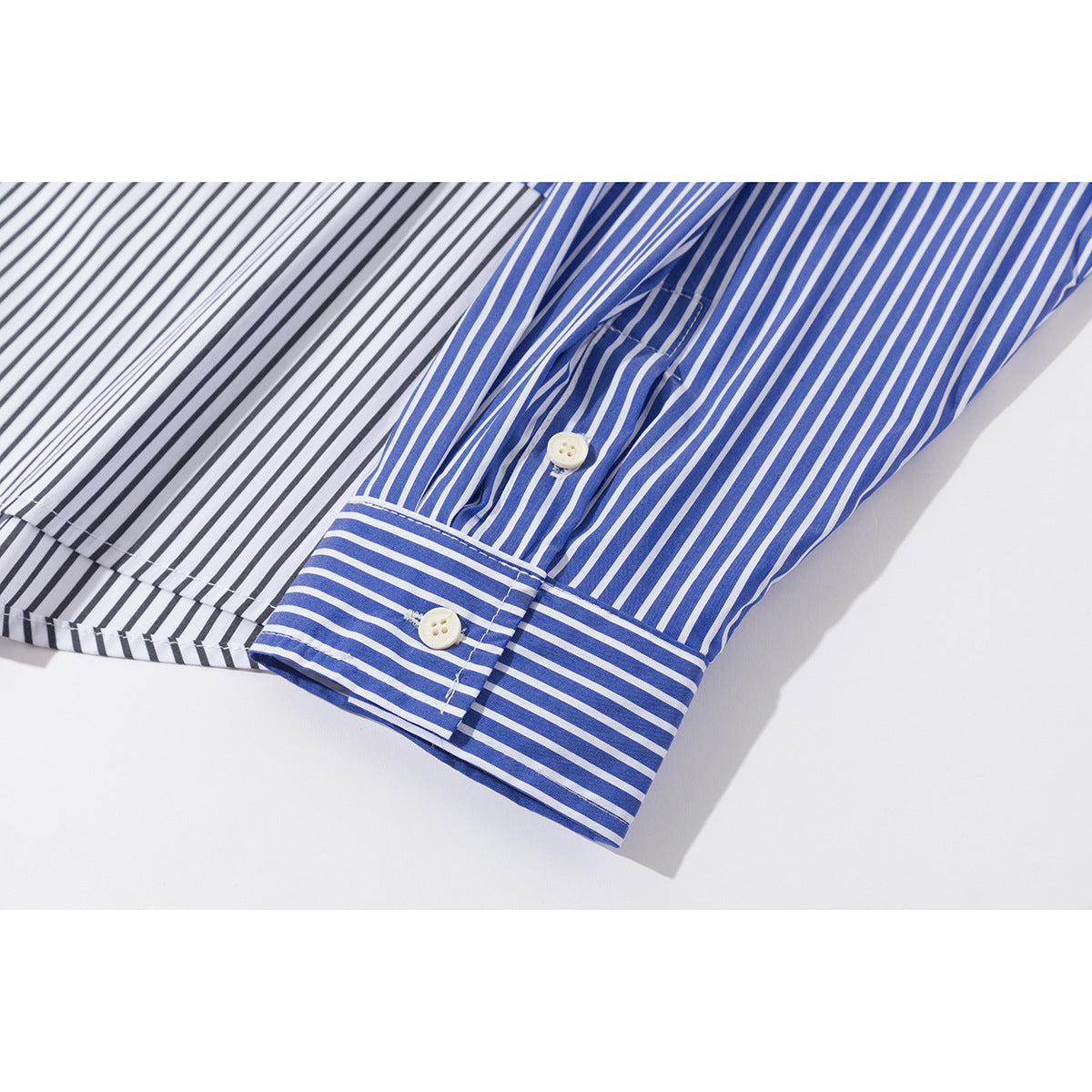 Close-up of a blue-and-white striped shirt sleeve and buttoned cuff beside contrasting black-and-white stripes.