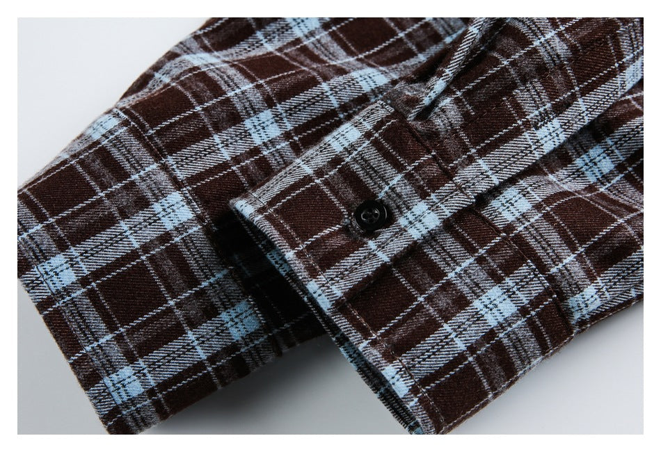 Close-up of the plaid shirt's buttoned cuff and sleeve seam.