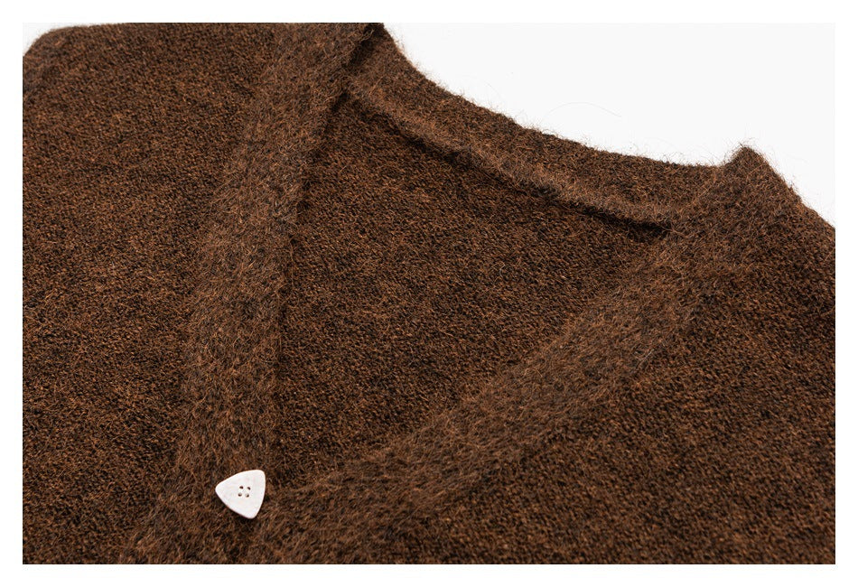 Close-up of a brown fuzzy knit cardigan collar and front edge with a small white triangular button.