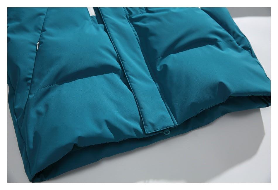 Close-up of a teal padded jacket showing the front placket, snap, and stitched panels.