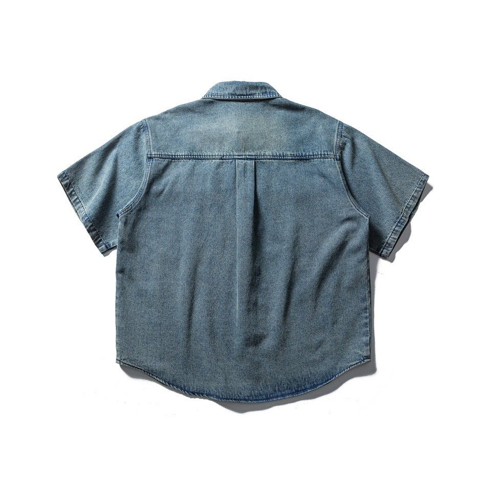 Back view of faded blue short-sleeve denim shirt showing yoke and center back pleat