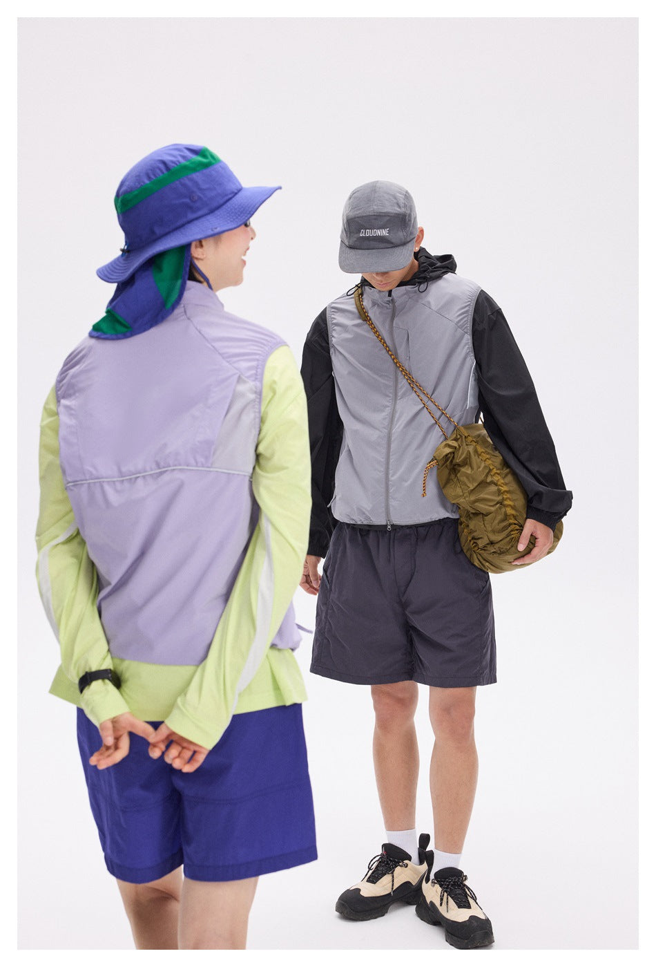 A rear view of a lavender vest with lime sleeves and blue shorts beside a model wearing a gray vest and dark shorts.