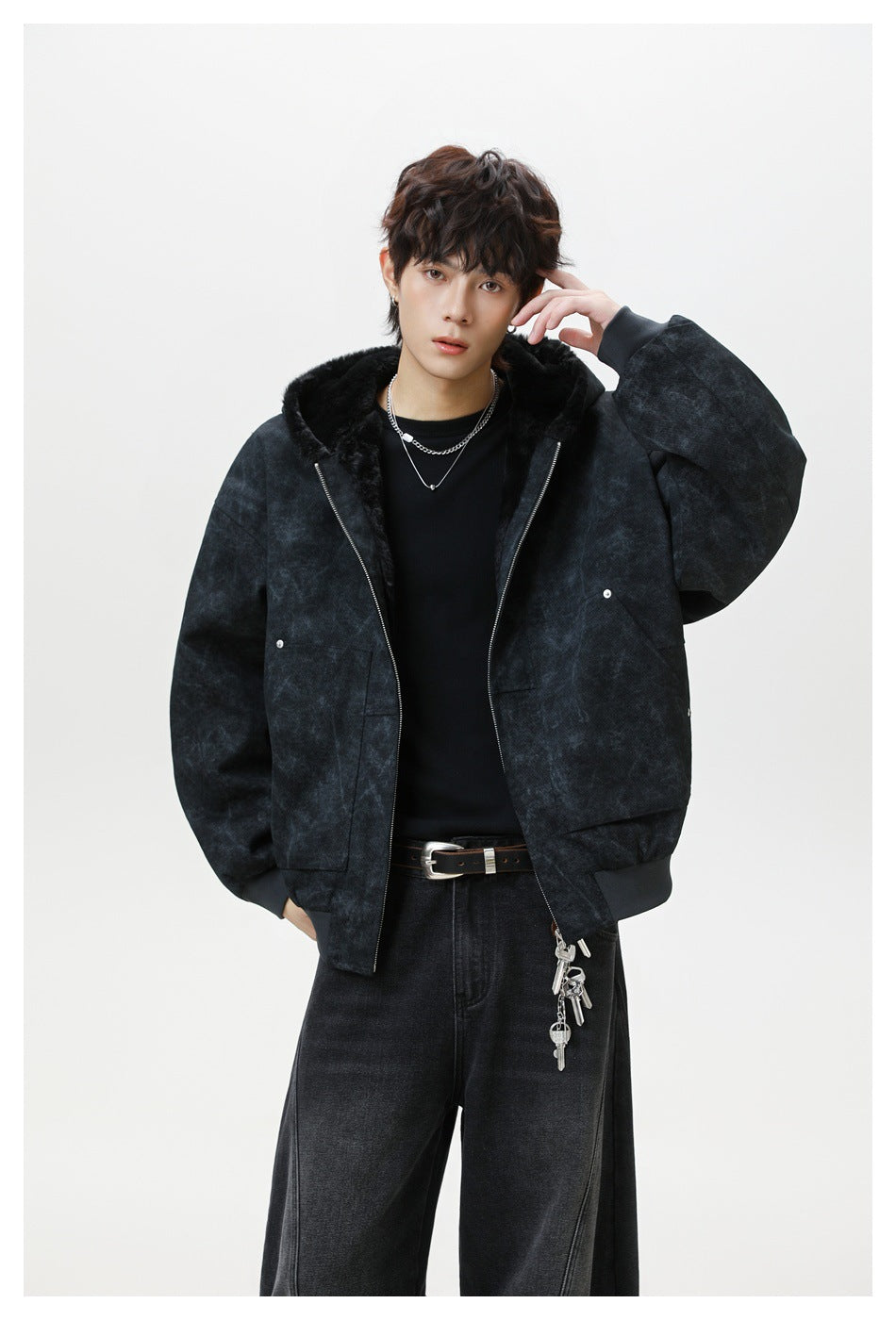Model poses in a charcoal mottled hooded jacket with black plush lining, silver zipper, and roomy front pockets.