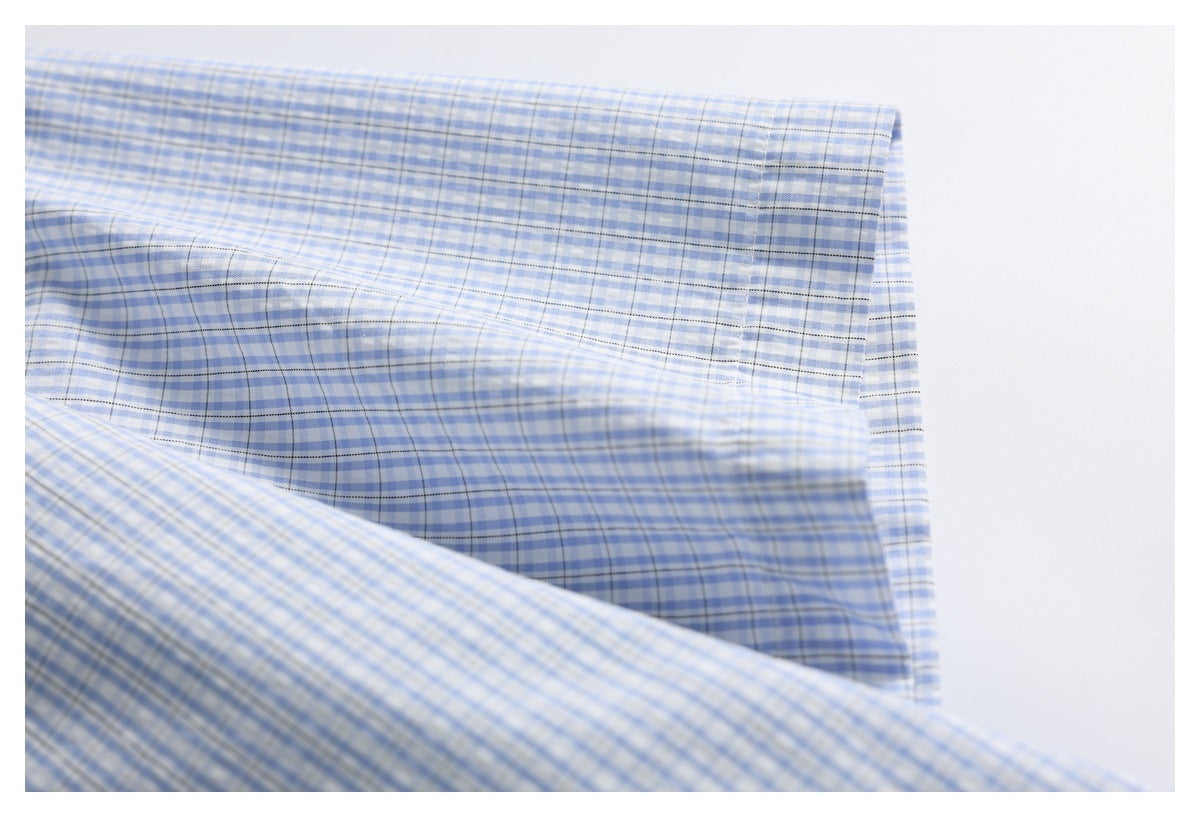 Close-up of a folded cuff on a blue-and-white checked shirt.
