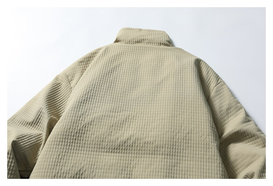 Back view of a beige quilted jacket laid flat, with a stand collar and gathered drawcord hem.