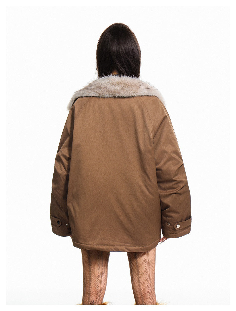 Back view of a model wearing a loose brown jacket with a wide light fur collar and buttoned cuffs.