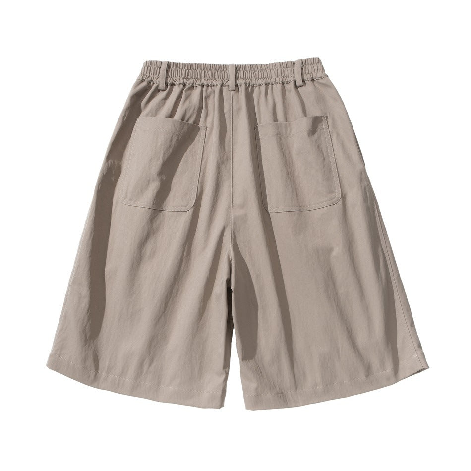 Back view of khaki wide-leg shorts with two large patch pockets and an elastic waistband