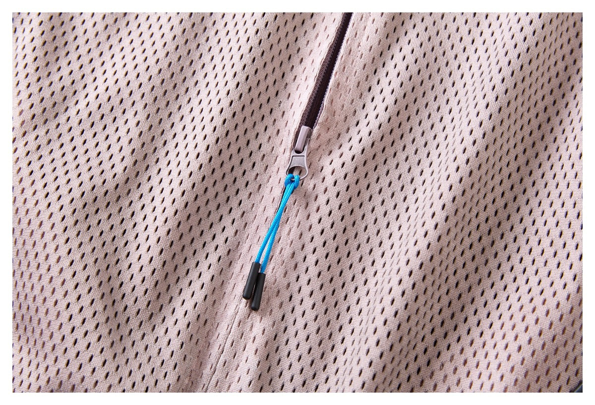 Close-up of a pale mauve perforated garment with a zipper and bright blue cord pull.