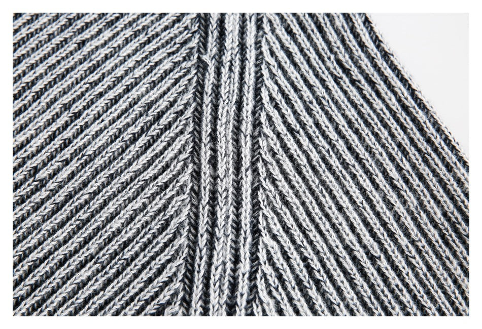 Close-up of black-and-white knit fabric with a raised central seam and diagonal ribbed texture.