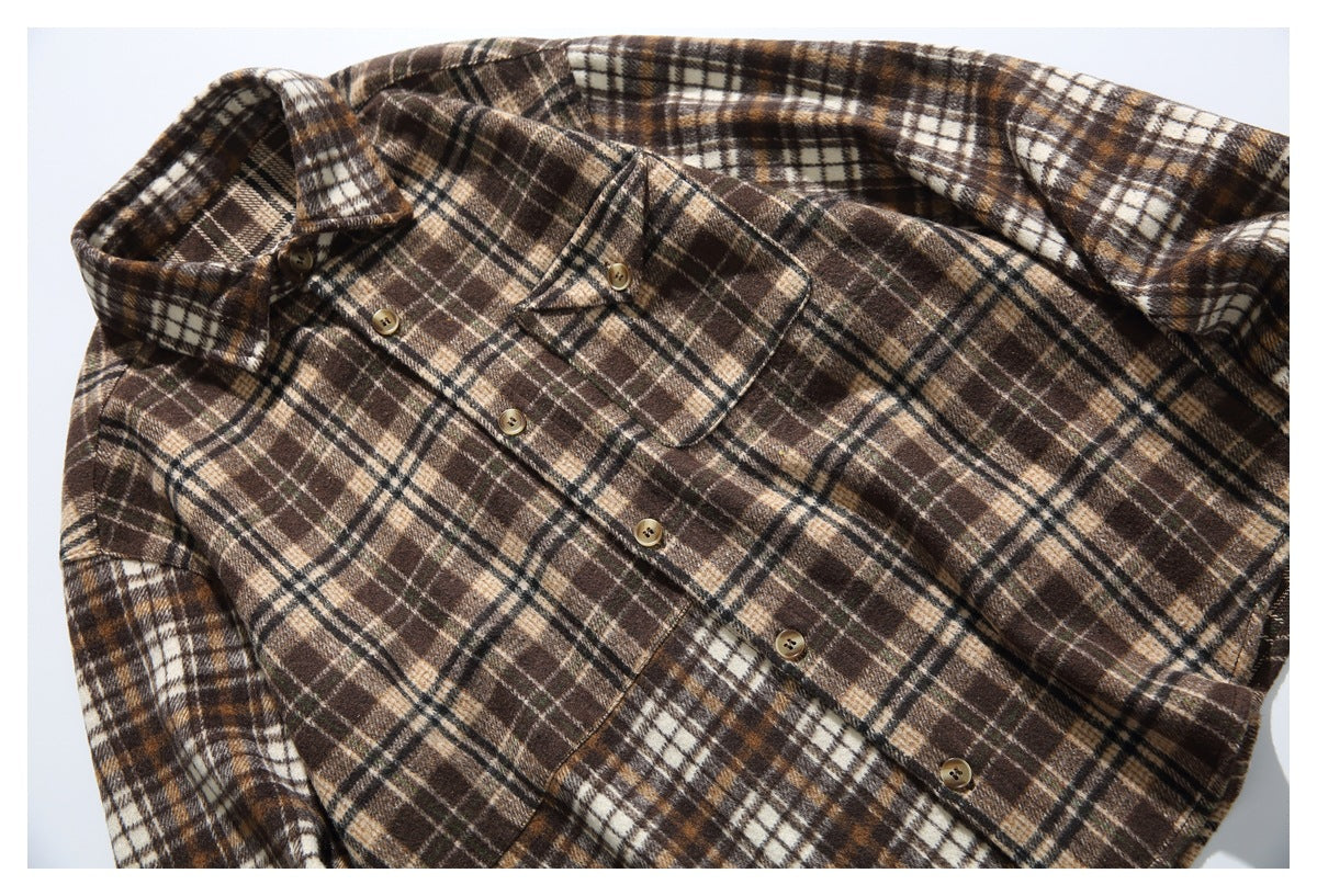 Close-up of brown plaid shirt showing collar, tan buttons, flap chest pocket and brushed plaid fabric