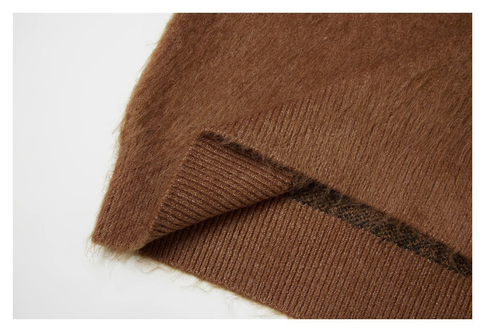 Close-up of the brown sweater hem with ribbed edging and a glimpse of the patterned knit inside.