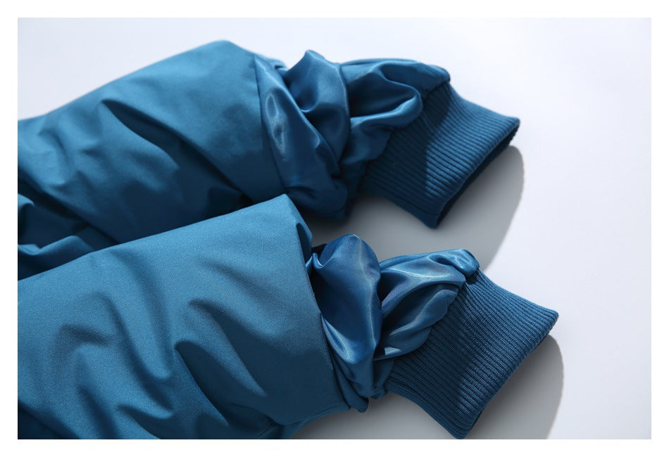 Close-up of the teal-blue jacket sleeves with ribbed knit cuffs.