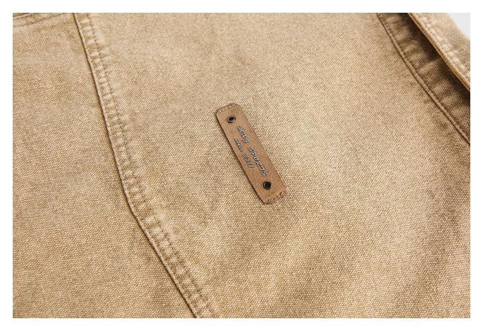 Close-up of tan garment fabric with a small leather tab bearing embossed lettering and numbers.