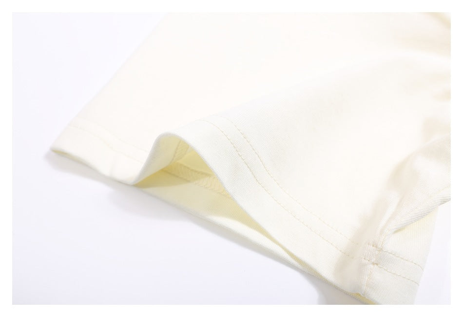 Close-up of the ivory T-shirt's double-stitched sleeve hem.