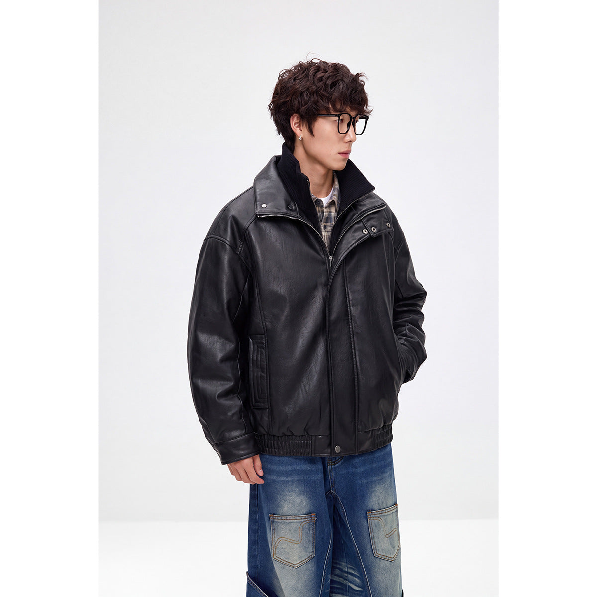Model wearing a black leather-look jacket with a high ribbed collar, zip and snap front, and elastic hem.