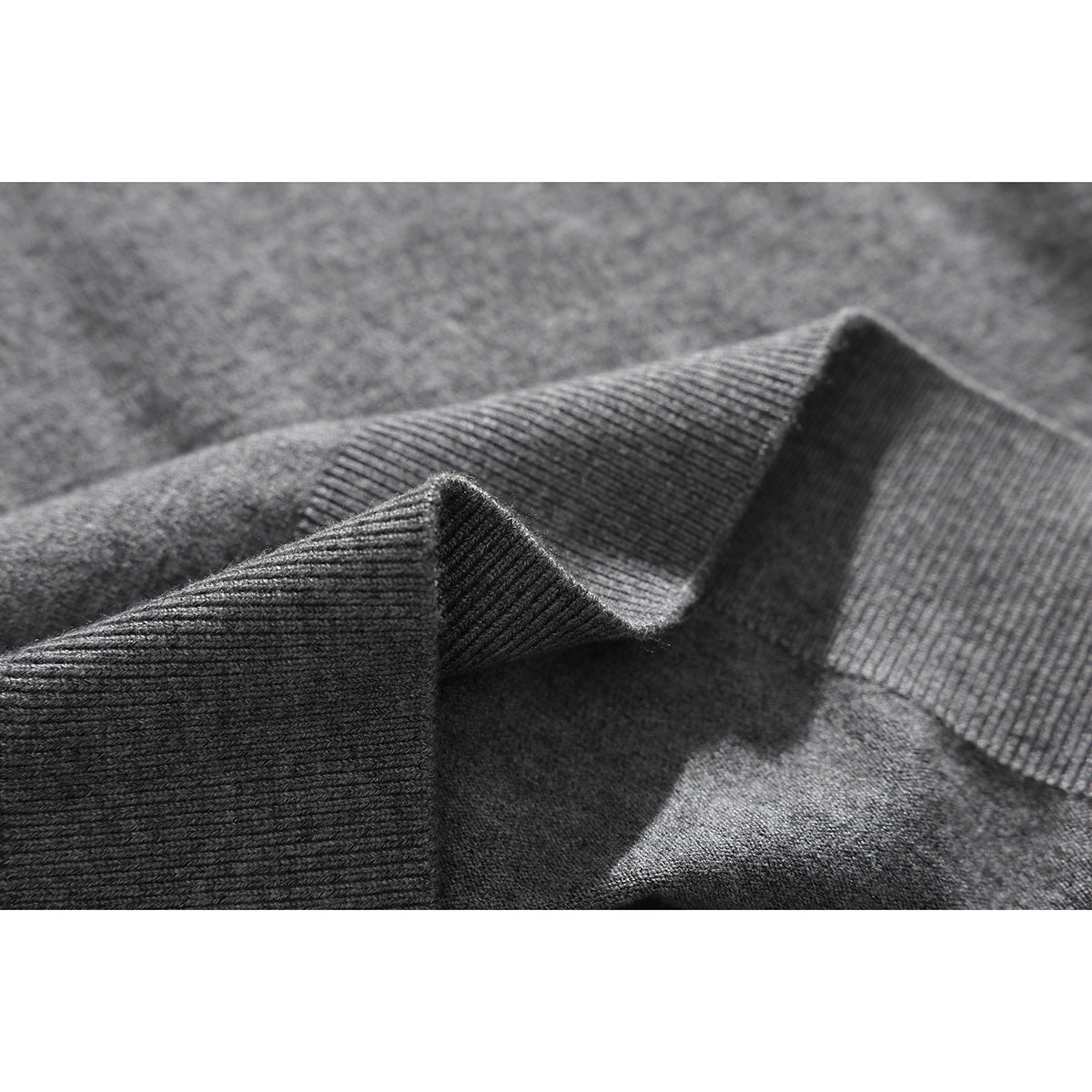 Macro view of gray knit fabric and a folded ribbed edge.