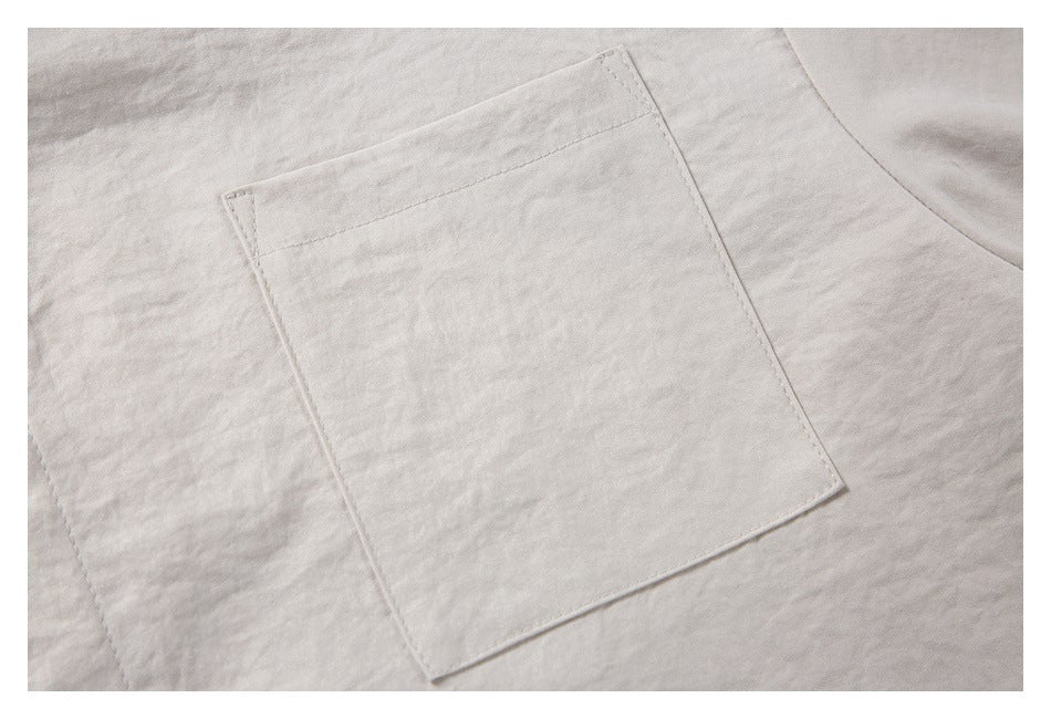 Close-up of a square patch pocket stitched onto a pale beige garment.