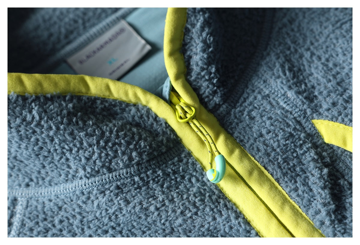 Close-up of the blue fleece jacket's yellow-green front zipper, cord pull, and turquoise zipper tab.
