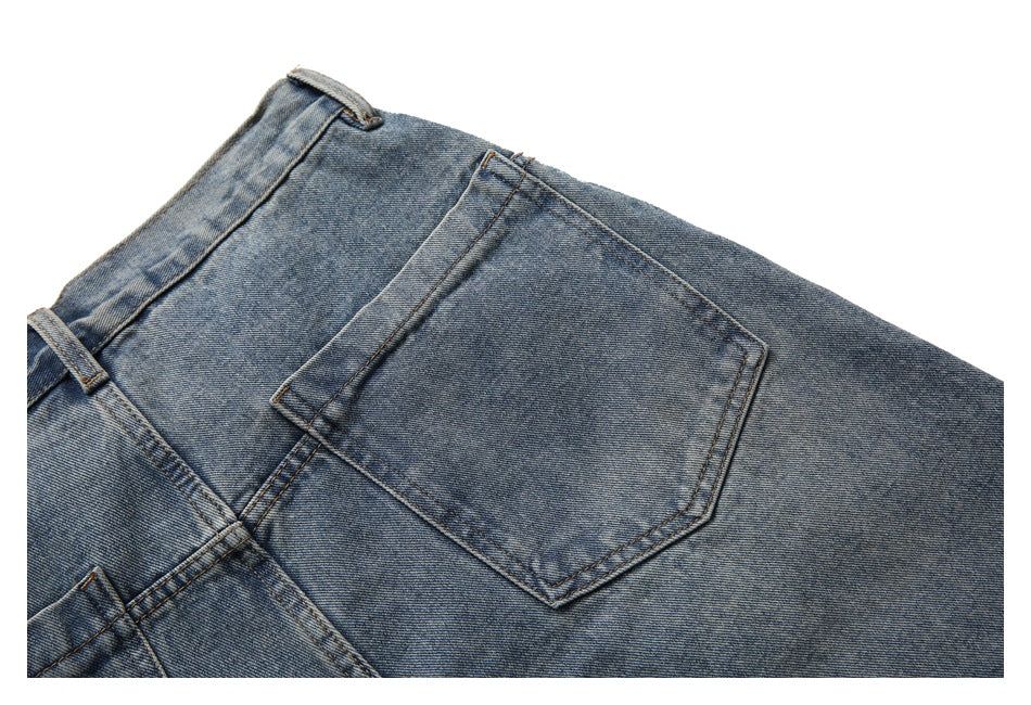 Close-up of a stitched back pocket on blue washed denim.