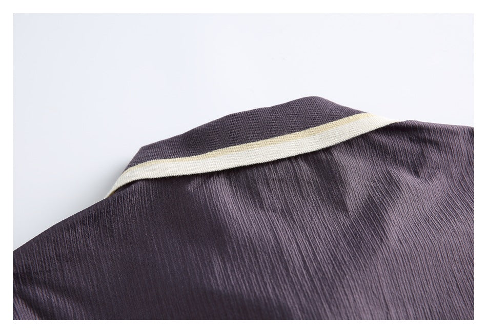 Close-up of a dark plum collar edged with cream and pale yellow stripes.