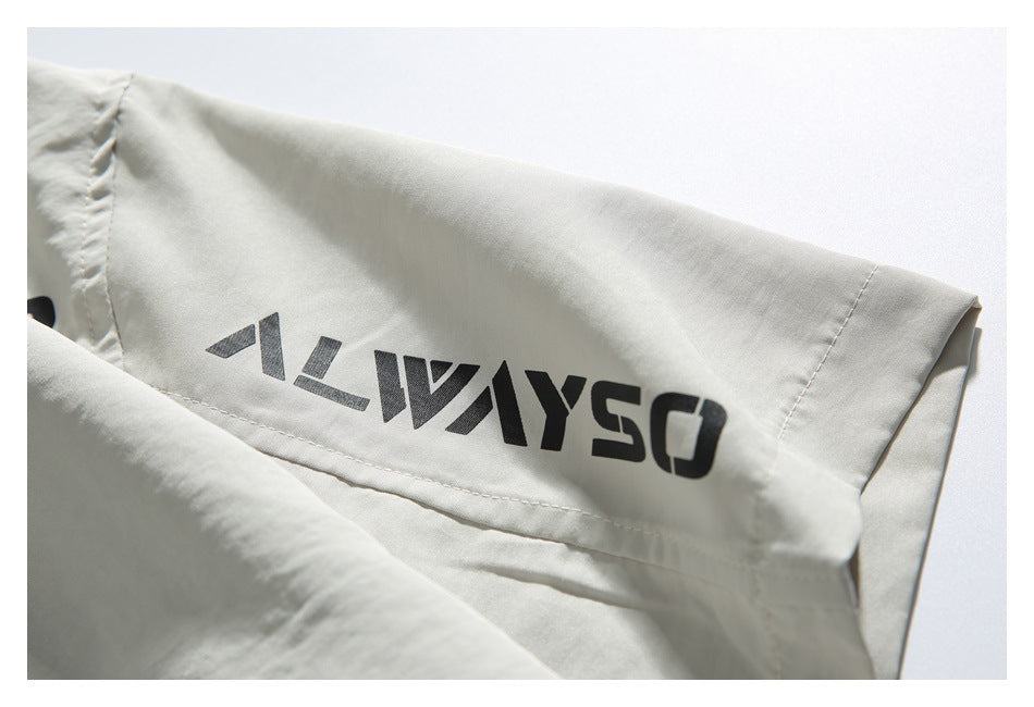 Close-up of an off-white garment sleeve with bold black stylized lettering printed on it.