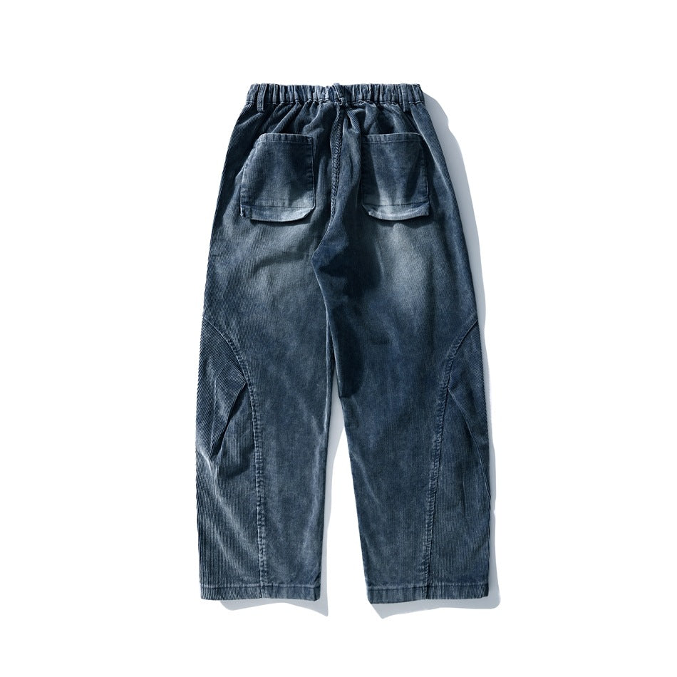 Full back view of dark blue trousers laid flat, with an elastic waistband, drawstring and two patch pockets.